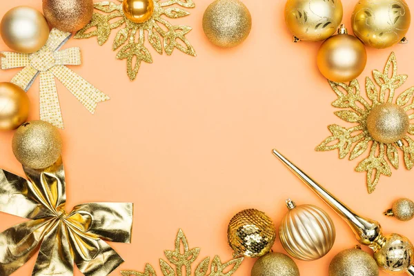 Frame of golden christmas decoration on orange background with copy space — Stock Photo