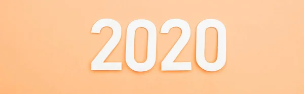 Draufsicht auf weiße Zahlen 2020 auf orangefarbenem Hintergrund, Panoramaaufnahme — Stockfoto