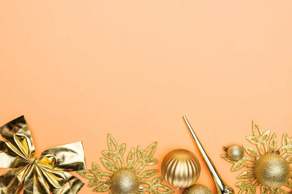 Top view of golden Christmas decor on orange background with copy space — Stock Photo