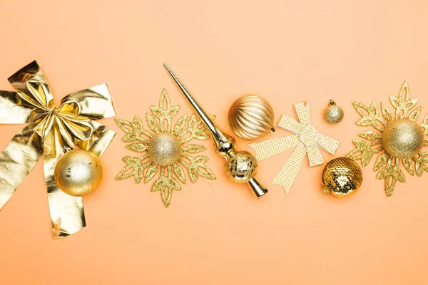 Blick von oben auf festliche goldene Weihnachtsdekoration auf orangefarbenem Hintergrund — Stockfoto