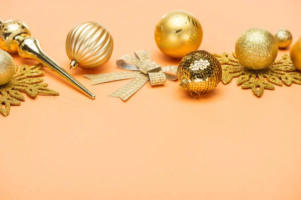 Décoration de Noël dorée festive sur fond orange avec espace de copie — Photo de stock