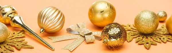 Festive golden christmas decoration on orange background, panoramic shot — Stock Photo