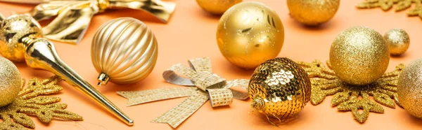 Festlich glänzende goldene Weihnachtsdekoration auf orangefarbenem Hintergrund, Panoramaaufnahme — Stockfoto