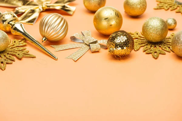 Festlich glänzende goldene Weihnachtsdekoration auf orangem Hintergrund mit Kopierraum — Stockfoto