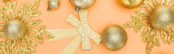 Top view of golden christmas decoration on orange background, panoramic shot — Stock Photo