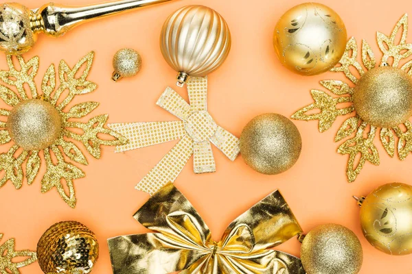 Top view of golden christmas decoration on orange background — Stock Photo