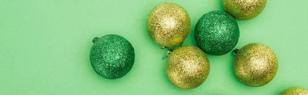 Vista superior de bugigangas de Natal brilhantes no fundo verde, tiro panorâmico — Fotografia de Stock