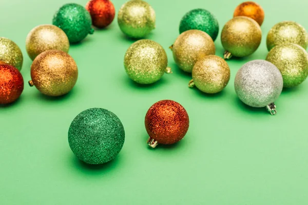 Foco seletivo de bugigangas de Natal multicoloridas no fundo verde — Fotografia de Stock