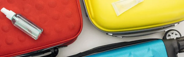 Panoramic shot of travel bags, tube and bottle on white background — Stock Photo