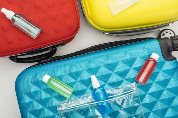 Top view of bright bottles with liquids on travel bag — Stock Photo