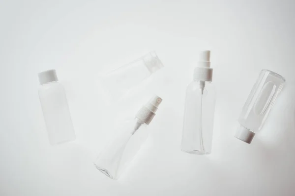 Draufsicht auf weiße Flaschen mit Flüssigkeiten auf weißem Hintergrund — Stockfoto