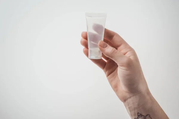 Cropped view of woman holding tube with liquid on white background — Stock Photo