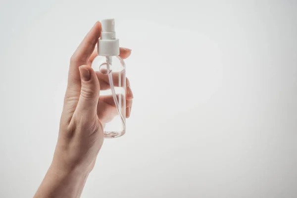 Vista ritagliata di donna bottiglia di tenuta con liquido su sfondo bianco — Foto stock