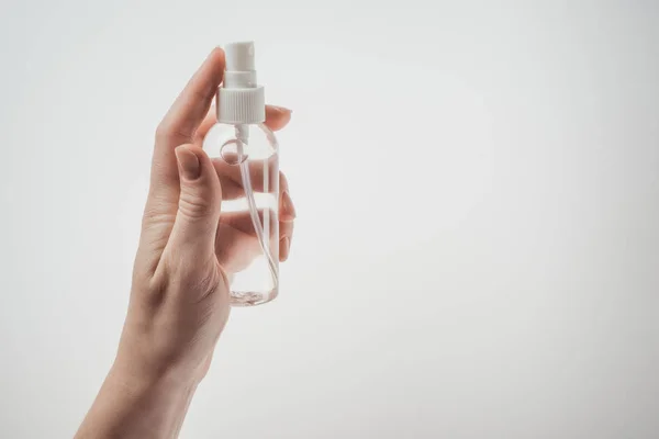 Vue recadrée de la femme tenant bouteille avec du liquide sur fond blanc — Photo de stock