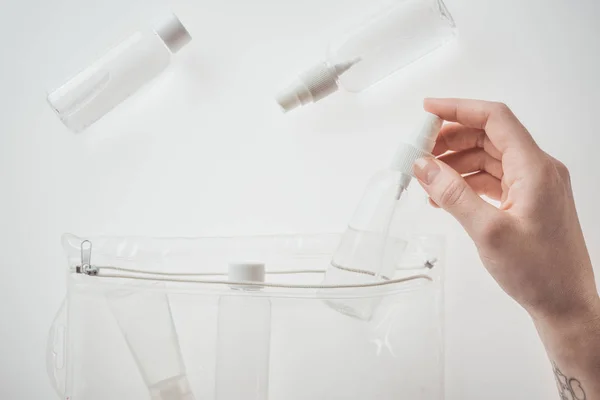 Vista ritagliata di donna bottiglia di tenuta con liquido su sfondo bianco — Foto stock