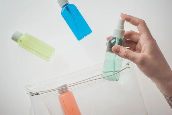 Vue recadrée de la femme tenant bouteille avec du liquide sur fond blanc — Photo de stock