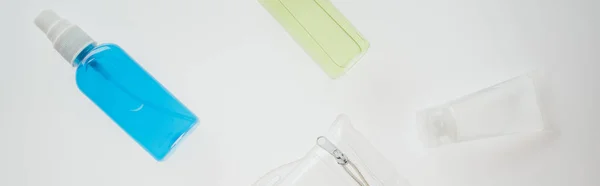 Panoramic shot of cosmetic bag and bottles with liquids on white background — Stock Photo