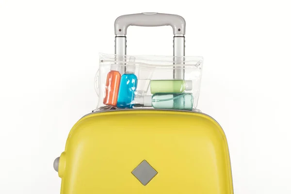 Bolsa de viaje con bolsa cosmética con botellas de colores con líquidos aislados en blanco - foto de stock