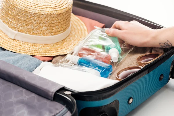 Vista ritagliata della donna imballaggio borsa da viaggio con sacchetto cosmetico con bottiglie — Foto stock