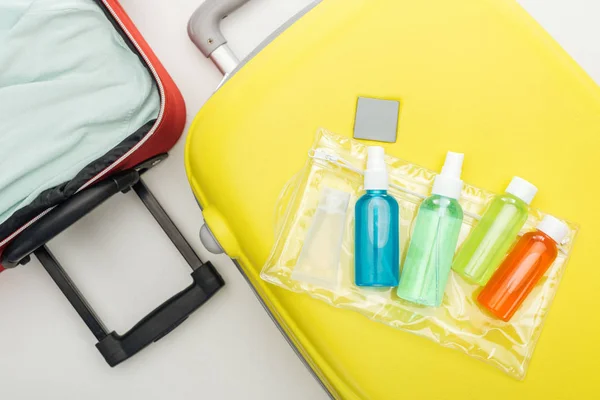 Vue du dessus du sac cosmétique et des bouteilles avec des liquides sur le sac de voyage — Photo de stock