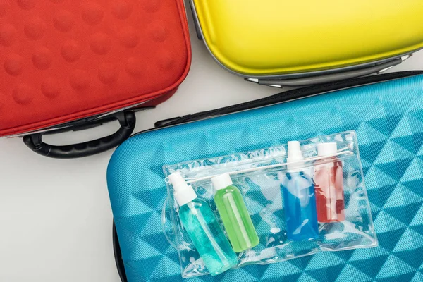 Vista superior de la bolsa de cosméticos y botellas con líquidos en la bolsa de viaje - foto de stock