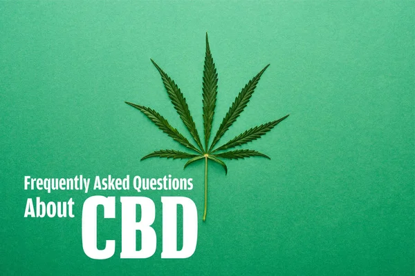 Top view of cannabis leaf on green background with frequently asked questions about cbd illustration — Stock Photo