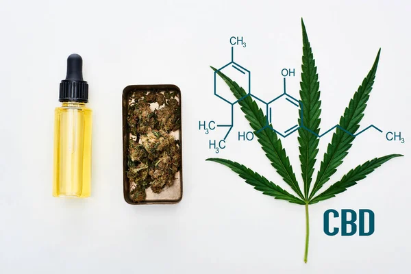 Vista superior de hoja de cannabis verde, aceite de cbd y cogollos de marihuana en caja de metal sobre fondo blanco con ilustración de molécula de cbd - foto de stock