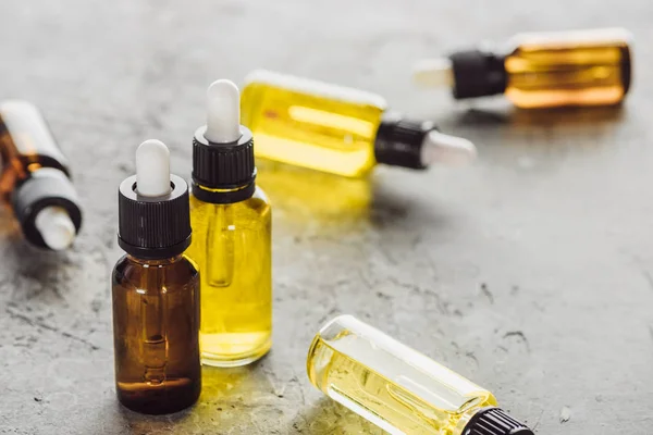 Selective focus of bottles with natural serum on grey stone surface — Stock Photo