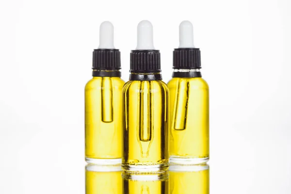 Bottiglie con siero naturale sulla superficie con riflessione isolata su bianco — Foto stock
