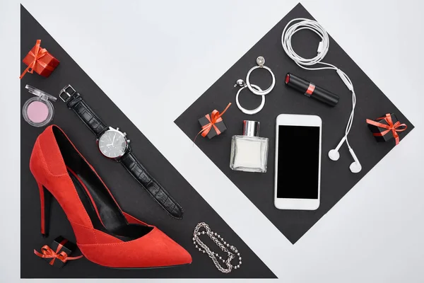 Top view of gadget, gift boxes, perfume, bracelets, decorative cosmetics, earrings, earphones, wristwatch, shoes — Stock Photo