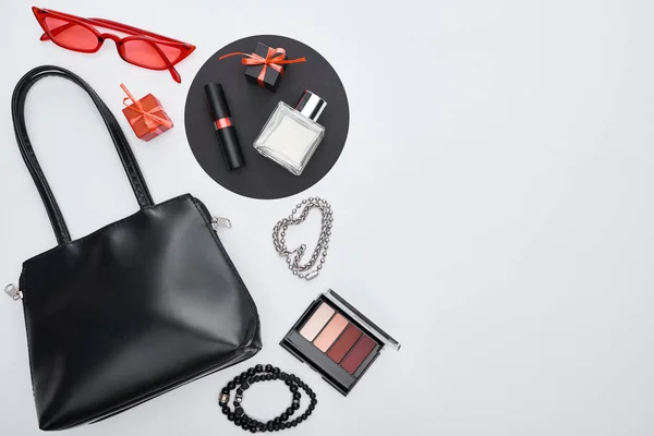 Draufsicht auf Tasche, Geschenkboxen, Parfüm, Armbänder, dekorative Kosmetik, Sonnenbrille — Stockfoto