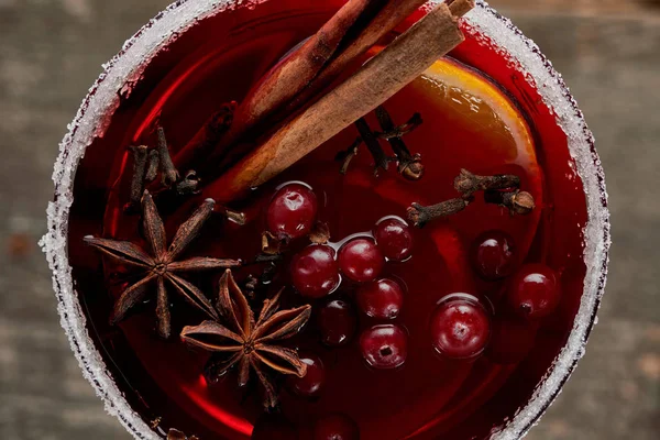 Blick von oben auf roten Glühwein mit Beeren, Anis, Orangenscheiben und Zimt im Glas mit Zucker dekoriert — Stockfoto