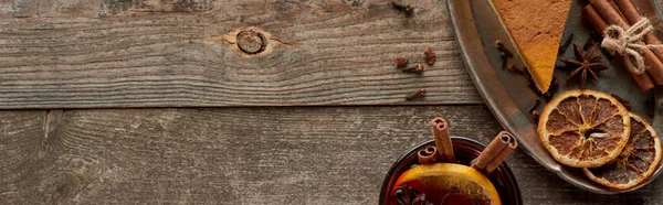 Vista dall'alto del vin brulè speziato rosso con anice, fette di arancia e cannella su tavolo rustico in legno, colpo panoramico — Foto stock