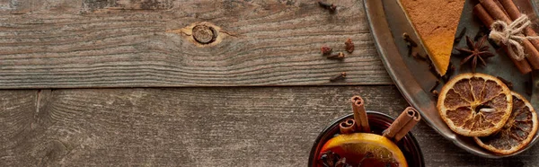 Vista superior de vino tinto especiado con anís, rodajas de naranja y canela sobre mesa rústica de madera, plano panorámico — Stock Photo