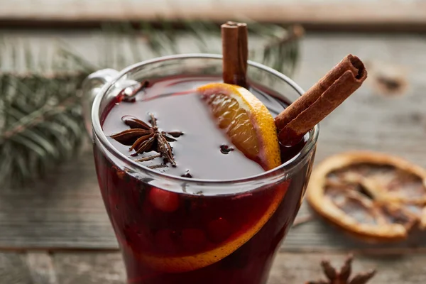 Close up view of red spiced mulled wine with berries, anise, orange slice and cinnamon — Stock Photo