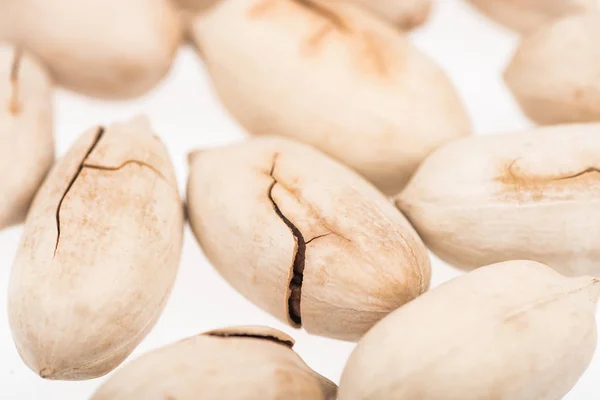 Vista de cerca de pistachos enteros en concha dispersos aislados en blanco - foto de stock