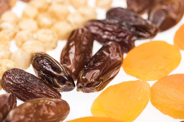 Close up view of dried apricots, dates and hazelnut isolated on white — Stock Photo