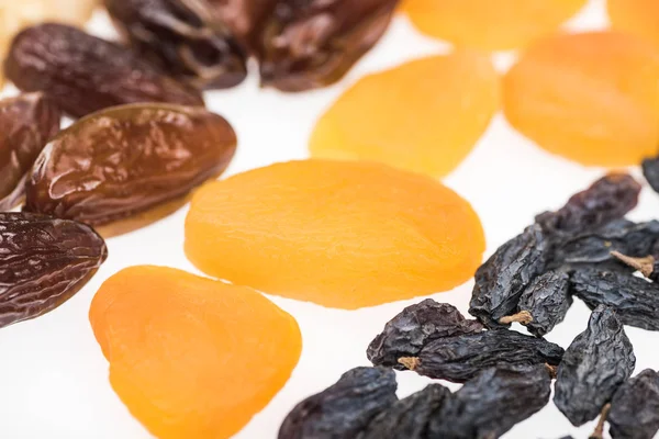 Vue rapprochée des abricots secs, raisins secs et dattes isolés sur blanc — Photo de stock