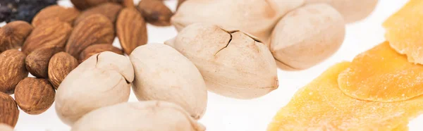 Vista de cerca de pistachos, almendras y mango seco aislado en blanco, plano panorámico - foto de stock