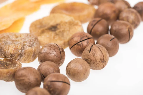 Закрыть вид сушеные ломтики манго, инжир и орехи макадамия изолированы на белом — стоковое фото