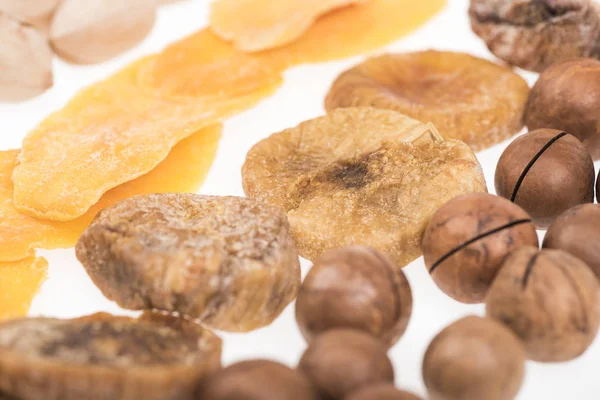 Nahaufnahme von getrockneten Mango-Scheiben, Feigen und Macadamia-Nüssen isoliert auf weiß — Stockfoto