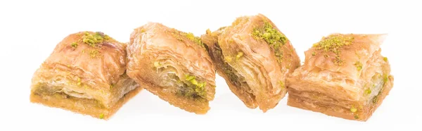 Fila de baklava tradicional de miel turca con frutos secos aislados en blanco, tiro panorámico - foto de stock