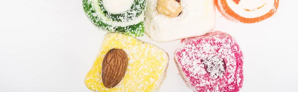 Top view of assorted delicious turkish delight in coconut flakes isolated on white, panoramic shot — Stock Photo