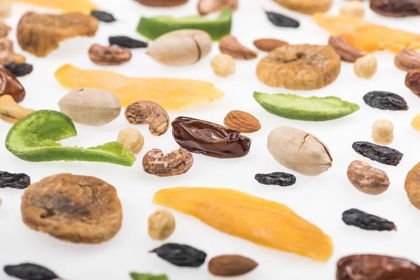 Vista de cerca de nueces surtidas, frutos secos y frutas confitadas aisladas en blanco - foto de stock