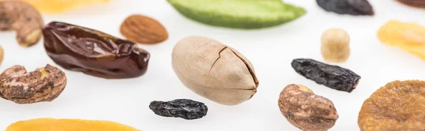 Vista de cerca de sabrosos frutos secos surtidos, frutas secas y frutas confitadas aisladas en blanco, plano panorámico - foto de stock