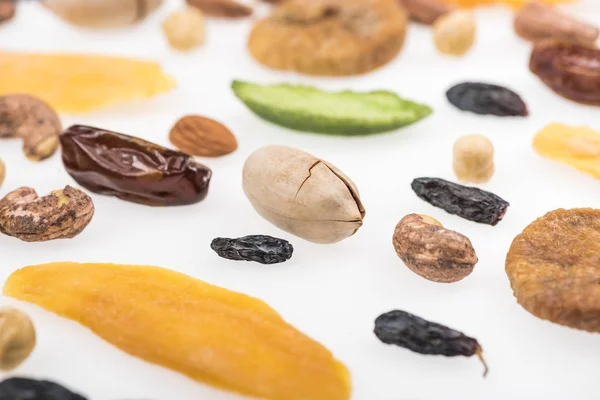 Vista de cerca de nueces surtidas, frutos secos y frutas confitadas aisladas en blanco - foto de stock