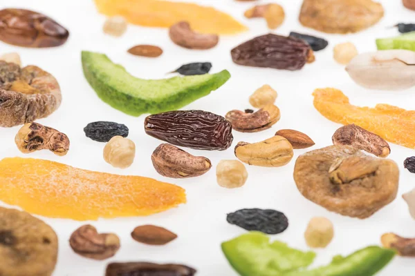 Vista de cerca de nueces surtidas, frutos secos y frutas confitadas aisladas en blanco - foto de stock