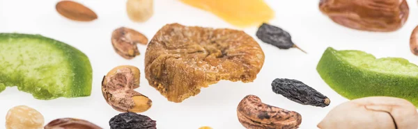 Vista de cerca de sabrosos frutos secos surtidos, frutas secas y frutas confitadas aisladas en blanco, plano panorámico - foto de stock