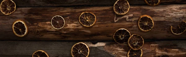 Вид сверху на сушеные цитрусовые ломтики на деревянном фоне, панорамный снимок — стоковое фото