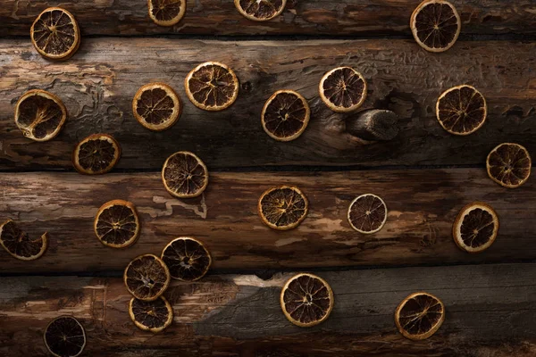 Вид сверху на сушеные цитрусовые ломтики на деревянном фоне — стоковое фото